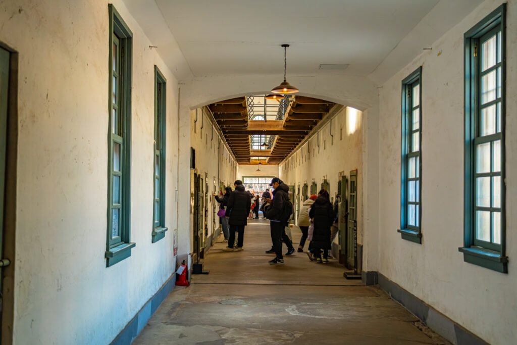 View of a narrow prison corridor with heavy iron doors at Seodaemun Prison History Hall.