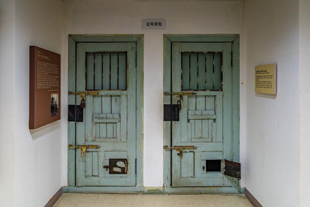 Heavy wooden prison doors with iron locks used for 'Prison Experience' at the Gwangju Student Independence Movement site.